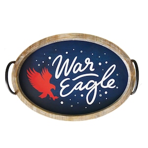 Könnte beinhalten: Ein ovales Serviertablett aus Holz mit schwarzen Metallgriffen. Das Tablett hat einen blauen Hintergrund mit weißer Aufschrift "War Eagle" und einer roten Silhouette eines Adlers.