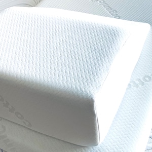 May include: A white pillow with a quilted surface. The pillow is rectangular with rounded edges and is made of a soft, breathable material.