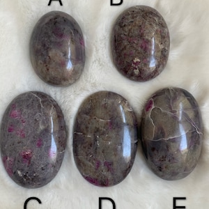 Peut inclure: Cinq pierres polies de forme ovale de couleur grise et rose. Les pierres sont étiquetées A, B, C, D et E.