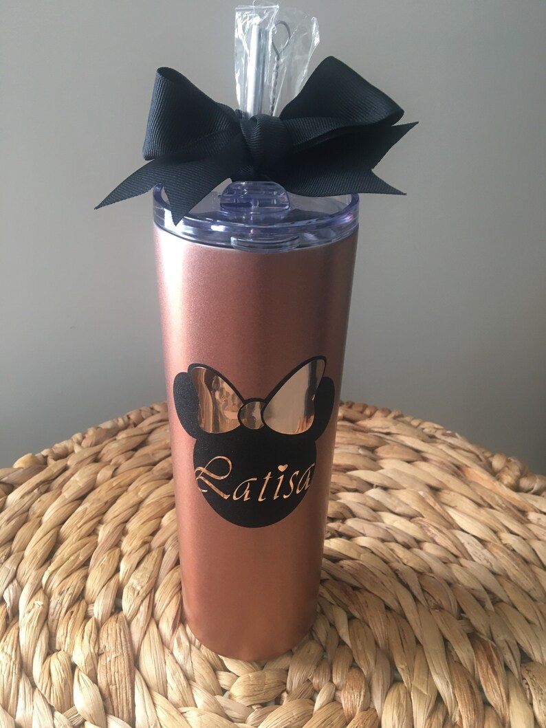 Puede incluir: Un vaso de acero inoxidable color oro rosa con un lazo negro y un dise&ntilde;o de Minnie Mouse negro y dorado con el nombre "Latisa" en &eacute;l.