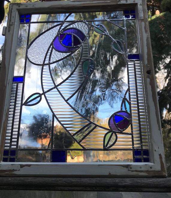 Stained glass panel in old window frame