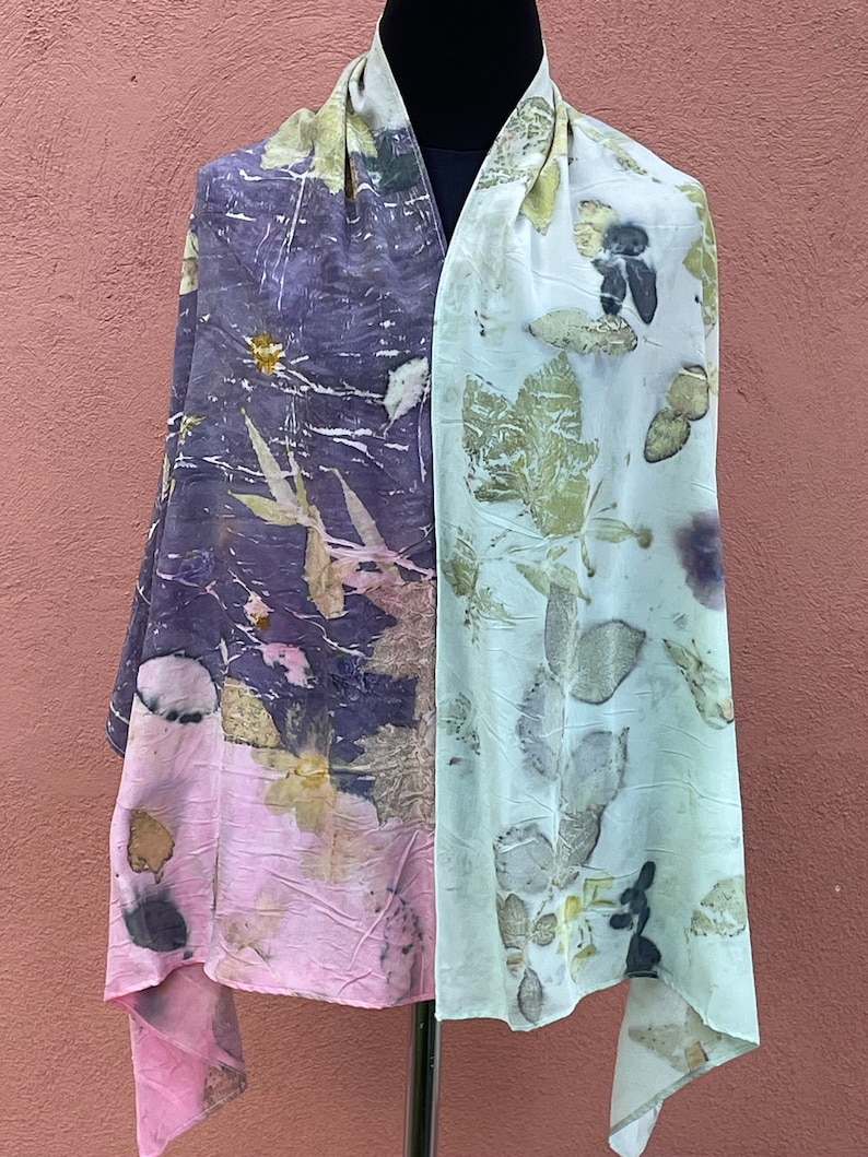 Pu&ograve; includere: Una sciarpa lunga e rettangolare con un motivo floreale rosa chiaro e viola da un lato e un motivo floreale verde chiaro dall'altro.
