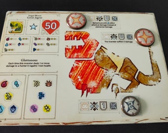 May include: A Monster Hunter World: The Board Game card for the Great Jagras monster. The card features a red heart with the number 50, a star, and a red and orange illustration of the monster. The card also includes text describing the monster's abilities, including "Gluttonous" and "Behaviours with inflict physical damage instead of elemental damage".