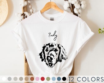 May include: White t-shirt with a black and white illustration of a dog's head and the name "Indy" written in cursive above the dog.