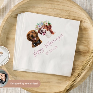 May include: White paper napkins with watercolor illustrations of two dogs. One dog wears a bow tie, the other a floral crown. The words "Happy Marriage!" and names are written in a cursive font. The napkins are on a wooden tray.