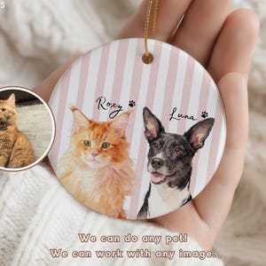 Pode incluir: Enfeite redondo e personalizado para animais de estima&ccedil;&atilde;o com retratos em aquarela de um gato chamado Roxy e um cachorro chamado Luna, em um fundo listrado rosa e branco. O enfeite tem uma corda dourada para pendurar. O texto "We can do any pet! We can work with any image."