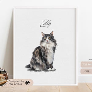 May include: A framed watercolor portrait of a cat named Lilly. The cat is a fluffy, medium-haired breed with gray, black, and white fur. The artwork is displayed on a white background, with the words "Designed by real artists!" at the bottom.