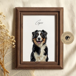 May include: A framed portrait of a dog named Cooper. The dog is an Australian Shepherd with black, white, and brown fur. The wooden frame is dark brown. The artwork is on a white background. A sticker on the right says "Designed by Real Artists."