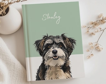 May include: A hardcover journal featuring a sage green and white cover with a custom digital illustration of a black, white, and tan dog. The name Stanley is printed in white script above the dog portrait, which shows a smiling canine face.