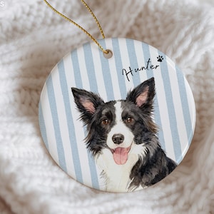 Pode incluir: Enfeite redondo de cer&acirc;mica com um retrato em aquarela de um c&atilde;o Border Collie, com pelo preto e branco, e o nome "Hunter". O fundo tem listras verticais azuis claras e brancas. Uma corda dourada &eacute; anexada para pendurar.