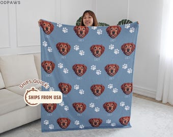 May include: A light blue fleece blanket featuring a repeating pattern of a brown dog's face and white paw prints. Below each dog face, the name Lucy is printed in white text. The top left corner displays the brand name MODPAWS in white text.