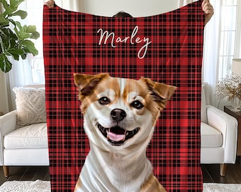 May include: A rectangular fleece blanket featuring a red and black plaid pattern. The blanket displays a large, centred graphic of a tan and white dog with its mouth open. The name Marley is printed in white cursive script above the dog image.