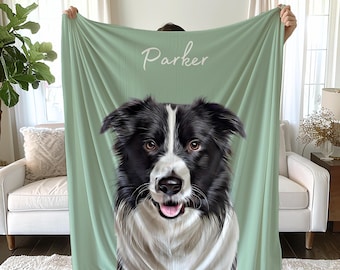 Puede incluir: Una manta de color verde salvia con una gran ilustración detallada de un perro Border Collie en blanco y negro. El nombre Parker está impreso en letra cursiva blanca sobre la cabeza del perro. La manta tiene una textura lisa y rectangular.