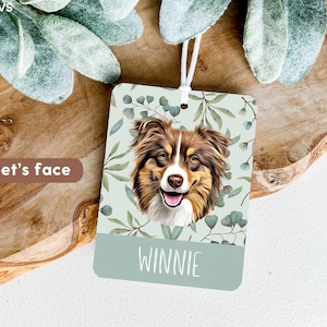 May include: A light green car air freshener with a floral design and a brown and white Australian Shepherd dog illustration. The text "WINNIE" is printed on the bottom of the air freshener.