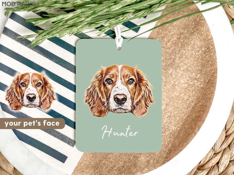 May include: A green car air freshener with a brown and white dog illustration and the name "Hunter" printed in white.
