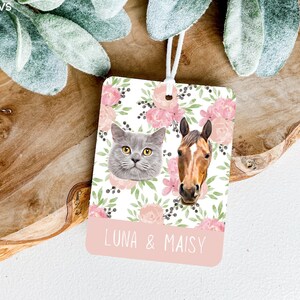 Peut inclure: Un diffuseur de parfum de voiture blanc avec un motif floral et des accents roses. Le diffuseur pr&eacute;sente un chat et un cheval avec les noms "Luna & Maisy" imprim&eacute;s en dessous.