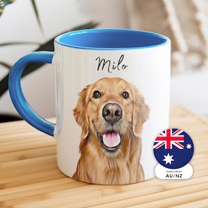 May include: A white ceramic mug with a blue interior and handle, featuring a realistic illustration of a golden retriever dog and the name Milo printed in black script above the dog. A circular sticker with the Australian flag is attached.