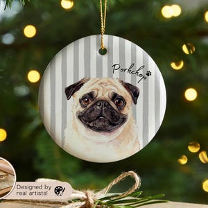 Pode incluir: Enfeite de Natal redondo de cer&acirc;mica com um retrato de um c&atilde;o pug. O fundo tem listras verticais cinza e brancas. A palavra "Porkchop" est&aacute; escrita acima do c&atilde;o, com uma pegada. Uma corda dourada &eacute; anexada para pendurar.