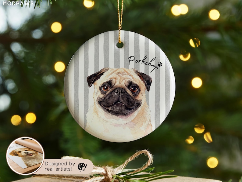 Pode incluir: Enfeite de Natal redondo de cer&acirc;mica com um retrato de um c&atilde;o pug. O fundo tem listras verticais cinza e brancas. A palavra "Porkchop" est&aacute; escrita acima do c&atilde;o, com uma pegada. Uma corda dourada &eacute; anexada para pendurar.