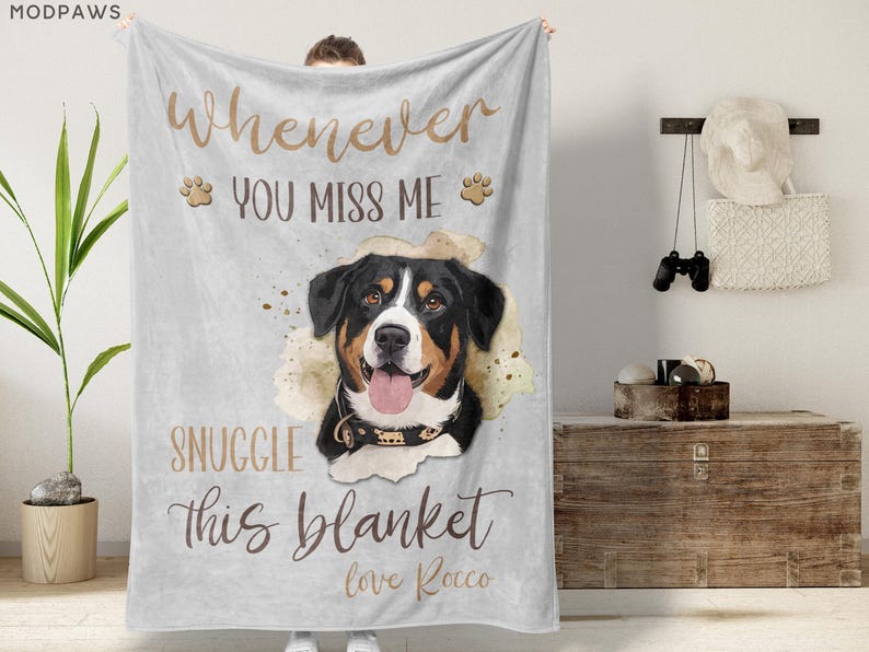 May include: A light gray blanket with a watercolor image of a dog. The blanket has the text "Whenever you miss me, snuggle this blanket, love Rocco" in brown script. The dog is black, brown, and white.