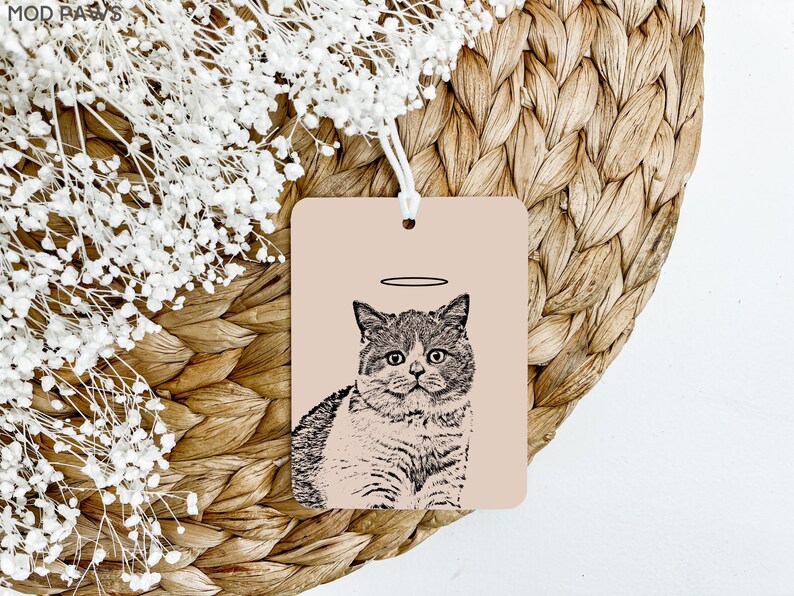 May include: A black and white illustration of a cat with a halo above its head. The cat is sitting on a light pink background.