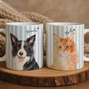 Puede incluir: Dos tazas de cerámica blanca con rayas verticales azul claro. La taza izquierda muestra una ilustración en acuarela de un perro blanco y negro con el nombre Hunter y una huella. La taza derecha muestra un gato naranja con el nombre Nala y una huella.
