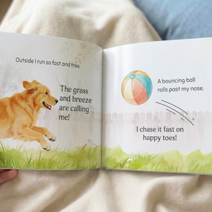 May include: Open children's book with illustrations. A golden retriever runs through grass, text reads "Outside I run so fast and free." and "The grass and breeze are calling me!" A beach ball rolls past with the text "I chase it fast on happy toes!"