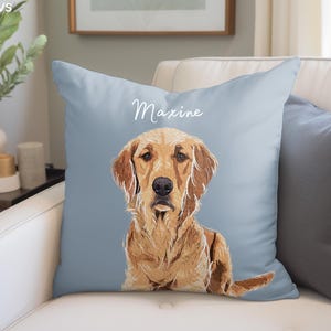 May include: A light blue throw pillow with the name "Maxine" printed in white script. A golden retriever dog is illustrated on the pillow, looking directly at the viewer.
