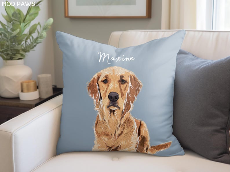 May include: A light blue throw pillow with the name "Maxine" printed in white script. A golden retriever dog is illustrated on the pillow, looking directly at the viewer.
