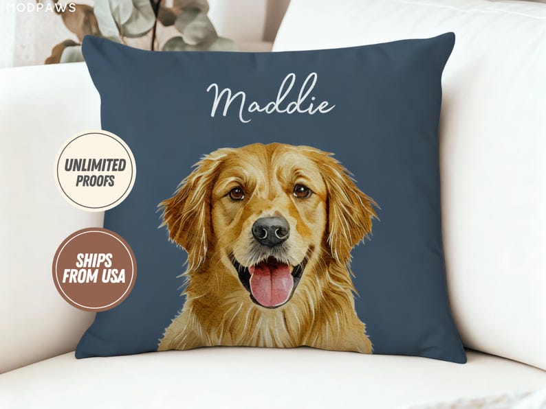 Puede incluir: Un coj&iacute;n cuadrado azul marino con un retrato de golden retriever y el nombre "Maddie" en escritura blanca. El perro tiene la lengua fuera. El coj&iacute;n est&aacute; sobre una superficie blanca. Tambi&eacute;n se ven dos insignias circulares.