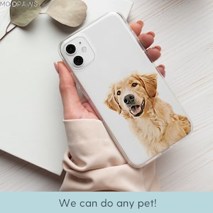 May include: A clear phone case with a printed image of a golden retriever dog. The dog is looking at the camera and has a happy expression. The case is designed to fit a smartphone.