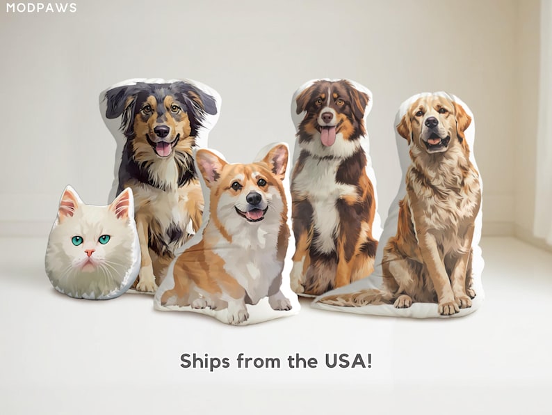 May include: A collection of pet-themed pillows featuring a white cat with blue eyes, a black and tan dog, a corgi, a brown and white dog, and a golden retriever. The pillows are shaped like the animals.