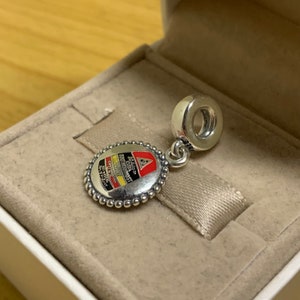 May include: Silver charm with a round, white enamel design featuring a red and yellow logo with the text "92nd  CHICAGO  SOUTHWESTERN  CONTINENTAL  AIRLINES  1971-1979".