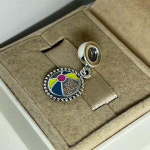 May include: Silver charm with a colorful beach ball design and the text "Cape May NJ".