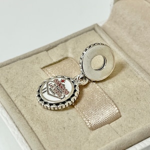 Puede incluir: Encanto de plata con un letrero de esmalte blanco que dice "Bienvenido a Las Vegas" con una estrella roja y letras rojas. El encanto est&aacute; en una caja blanca con una cinta plateada.