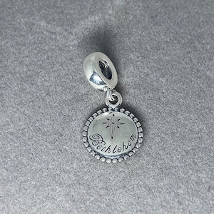 May include: Silver charm with a round pendant featuring a star of Bethlehem and the word "Bethlehem" engraved on it.