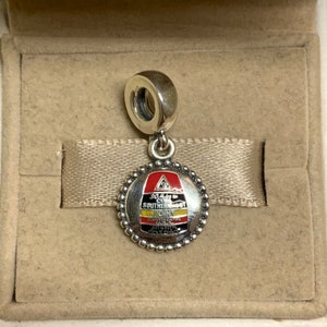 May include: Silver charm with a red, yellow, and black enamel design. The charm features the text "90 Miles to Cuba Southernmost Point Continental USA Key West Florida".