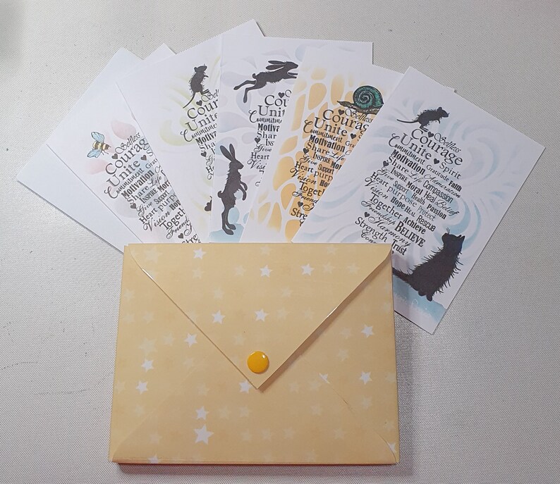 May include: A set of six cards with a yellow envelope. Each card features a different animal silhouette and the word "Courage" with a list of words related to courage, such as "unite", "motivation", "inspire", and "believe".