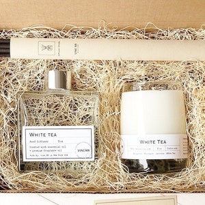 May include: A gift box containing a reed diffuser, a candle, and diffuser sticks. The diffuser and candle are labeled "White Tea". The box is filled with straw and includes a card. The diffuser is 5 oz.