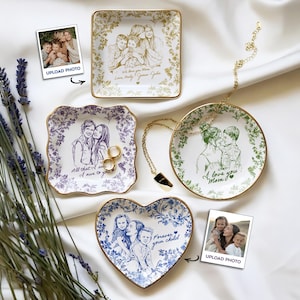 May include: A collection of personalized ceramic trinket dishes in various shapes: square, round, heart, and scalloped. Each dish features a custom family portrait and decorative floral borders. Gold rims and the text "We love you Mom", "All that I owe to you", and "Forever your child" are visible.