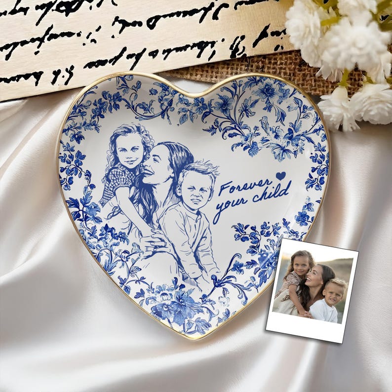 May include: Heart-shaped ceramic plate with a blue and white floral design and a gold rim. The plate features a family portrait and the text "Forever your child". A small photo is next to the plate.