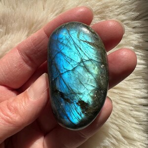 以下が含まれることがあります： 黒いハンドルと「But First, Coffee」のテキストが黒い太字で書かれた白いセラミックマグ。マグは木製の表面に置かれています。マグの高さは10cmです。