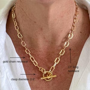 May include: A gold chain necklace with a toggle clasp. The necklace is 17 inches long and the clasp is 0.6 inches in diameter.