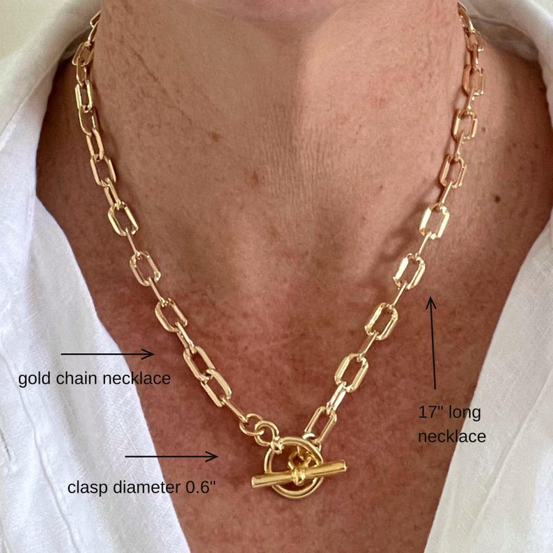 May include: A gold chain necklace with a toggle clasp. The necklace is 17 inches long and the clasp is 0.6 inches in diameter.