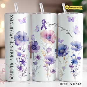 以下が含まれることがあります： 紫とピンクの色合いの花柄デザインの白いタンブラー。蝶と「DOMESTIC VIOLENCE AWARENESS」と「Support Encourage Empower」の文字が特徴です。ストローと蓋が含まれています。