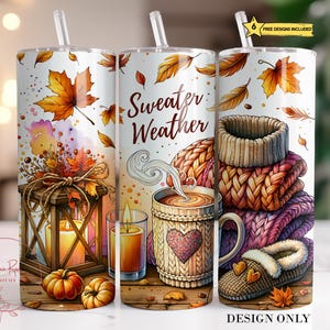 May include: Three white insulated tumblers with autumn designs. One shows a lantern, pumpkins, and leaves. Another says "Sweater Weather" with a coffee mug and a heart. The third shows a stack of sweaters and a slipper. Includes a straw.