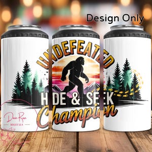 May include: White can cooler with a black top and bottom. The design features a silhouette of Bigfoot walking in front of a sunset, with the words "Undefeated Hide & Seek Champion". Green pine trees and the text "Design Only" are also visible.