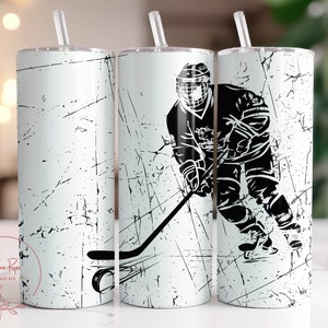 May include: Three white stainless steel tumblers with black hockey player graphics. The tumblers have a distressed white background with black lines.