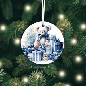 K&ouml;nnte beinhalten: Runder Weihnachtsschmuck mit einer Aquarellillustration eines Teddyb&auml;ren mit blauer Schleife, umgeben von blau verpackten Geschenken und einem Weihnachtsbaum. Der Schmuck h&auml;ngt an einem wei&szlig;en Band. Auf dem Schmuck steht "Digital Design Only".