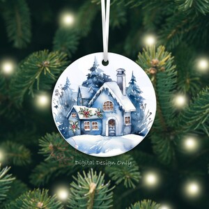 K&ouml;nnte beinhalten: Runder Weihnachtsschmuck mit einem Aquarellgem&auml;lde eines schneebedeckten blauen Hauses mit Schornstein und Stechpalmenakzenten. Der Schmuck h&auml;ngt an einem wei&szlig;en Band vor dem Hintergrund eines Weihnachtsbaums. Der Text auf dem Ornament lautet "Digital Design Only."